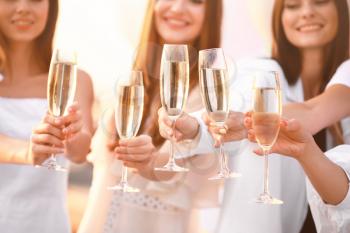 Beautiful young women drinking champagne at hen party outdoors�