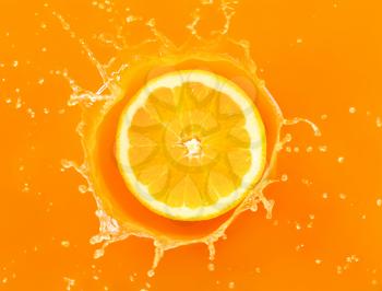 Falling of orange piece into juice, top view�