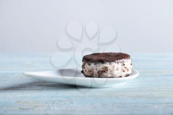 Plate with tasty ice cream cookie sandwich on wooden table�