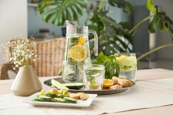 Healthy infused water with ingredients on table�