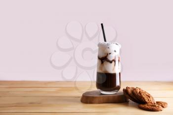 Glass of tasty frappe coffee and cookies on table�