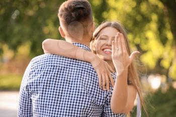 Happy engaged couple hugging outdoors�