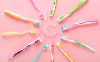 Many tooth brushes on color background�