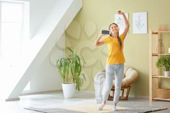 Dancing woman listening to music at home 