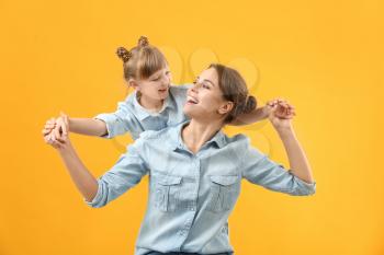 Portrait of happy mother and daughter on color background�