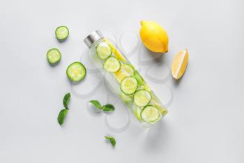 Bottle of cold cucumber water on light background�