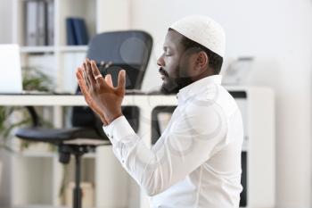 African-American Muslim man praying in office�