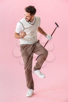 Handsome happy male golfer on color background�