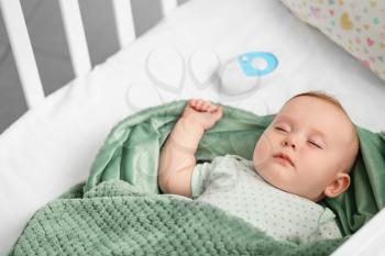 Cute little baby with radio nanny sleeping in crib�