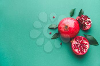 Ripe tasty pomegranates on color background�