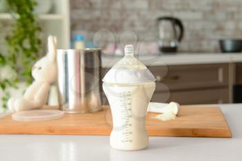 Bottle of baby milk formula on table indoors�