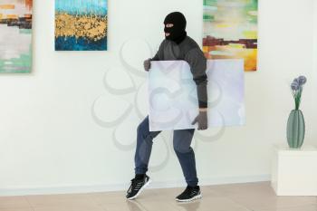 Thief stealing picture from art gallery�