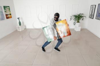 Thief stealing picture from art gallery�