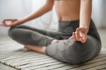 Beautiful young woman practicing yoga at home, closeup�