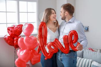 Happy young couple celebrating Valentine's Day at home�