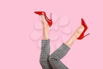 Legs of young woman in high-heeled shoes on color background�