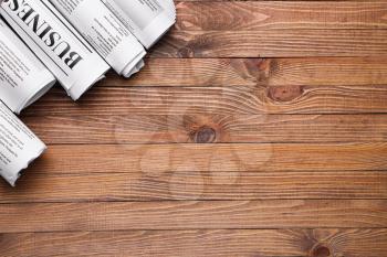 Many newspapers on wooden background�