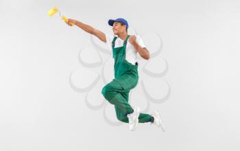 Jumping African-American decorator on white background�