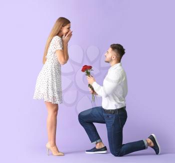 Happy man giving bouquet of flowers for his girlfriend on color background�