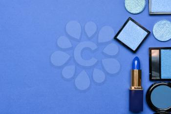 Set of blue makeup cosmetics on color background�