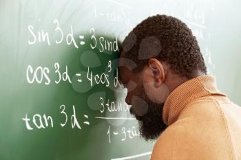 African-American math teacher in despair near blackboard�