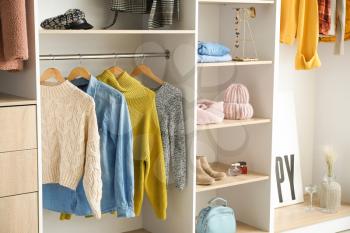 Modern wardrobe with stylish winter clothes and accessories�