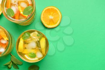 Glasses of tasty cold ice tea on color background�