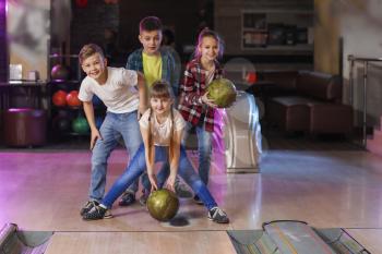 Little children playing bowling in club�