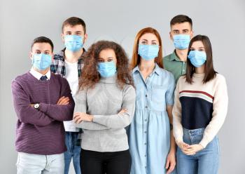 Group of people with protective masks on grey background. Concept of epidemic�