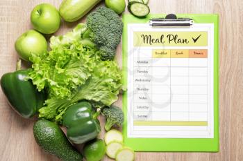 Healthy products and meal plan on wooden background�