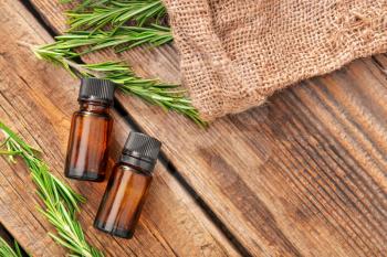 Bottles of rosemary essential oil on table�