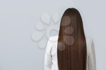 Young woman with beautiful straight hair on grey background�