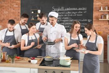 Male chef and group of young people during cooking classes�