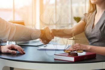 Man and lawyer shaking hands in office�