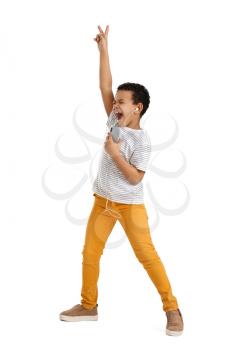 Little African-American boy listening to music and dancing against white background�