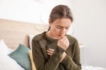 Ill woman coughing at home�