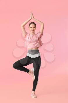 Sporty young woman training against color background�