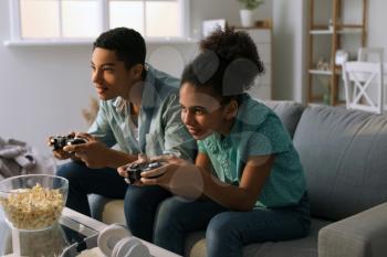 African-American teenagers playing video game at home�