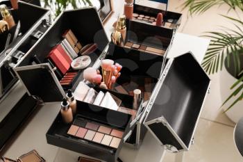 Case of professional makeup artist with decorative cosmetics on table�