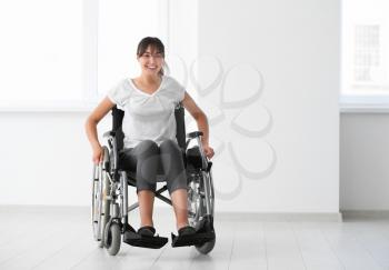 Young woman in wheelchair indoors�