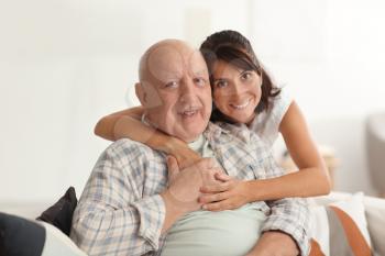 Happy elderly man with his daughter at home�