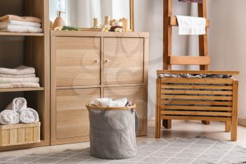 Laundry basket with dirty towels on floor in bathroom�