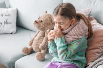 Sick little girl with medicine at home�