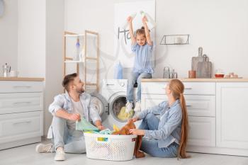 Happy family doing laundry at home�