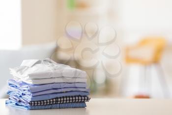 Stack of clean clothes on table in room�