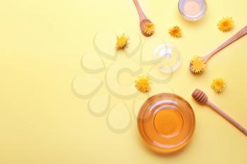 Jar of dandelion honey on color background�