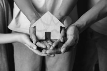 Hands of family with small house, closeup�