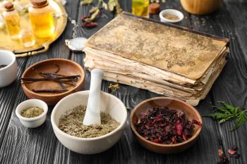 Old book and ingredients for preparing potions on alchemist's table�