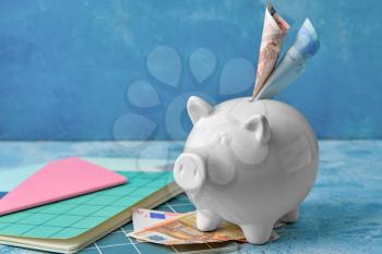 Piggy bank with money on color background�