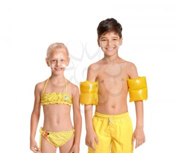 Little children with sun protection cream on their faces against white background�